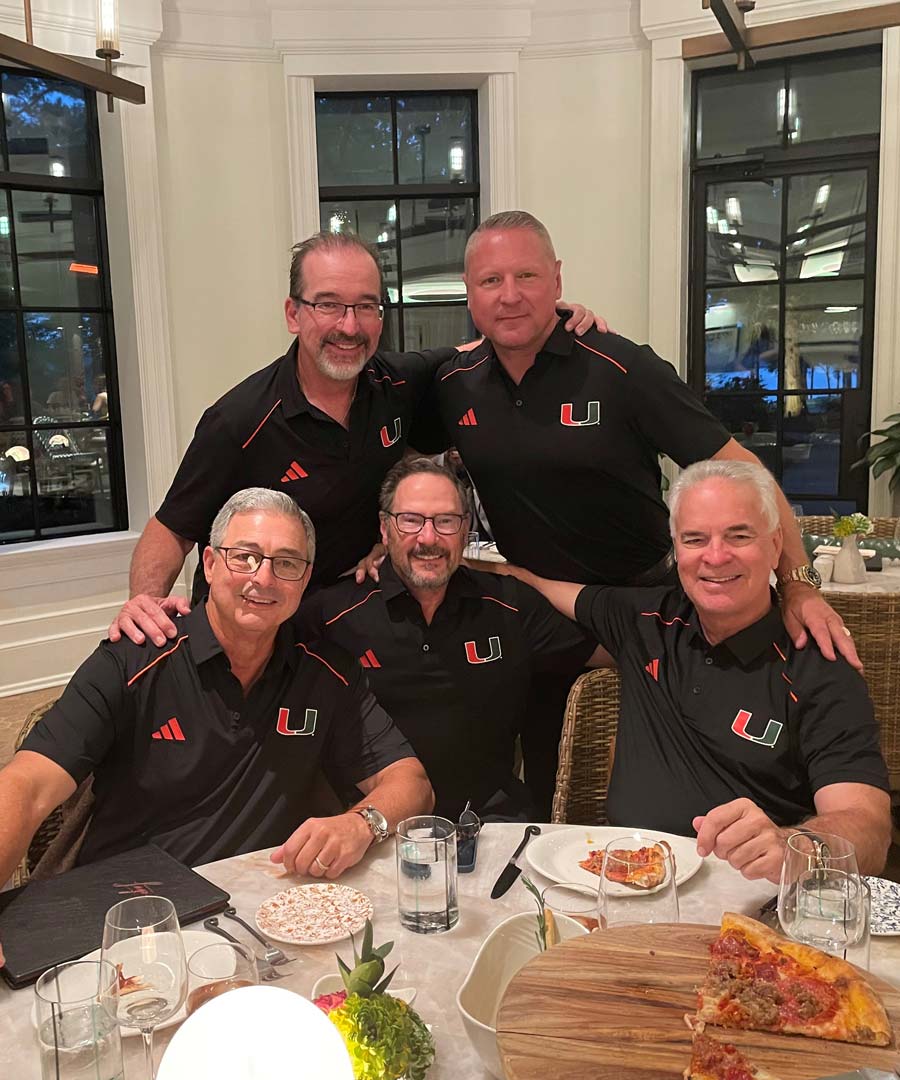 Men posing around dinner table
