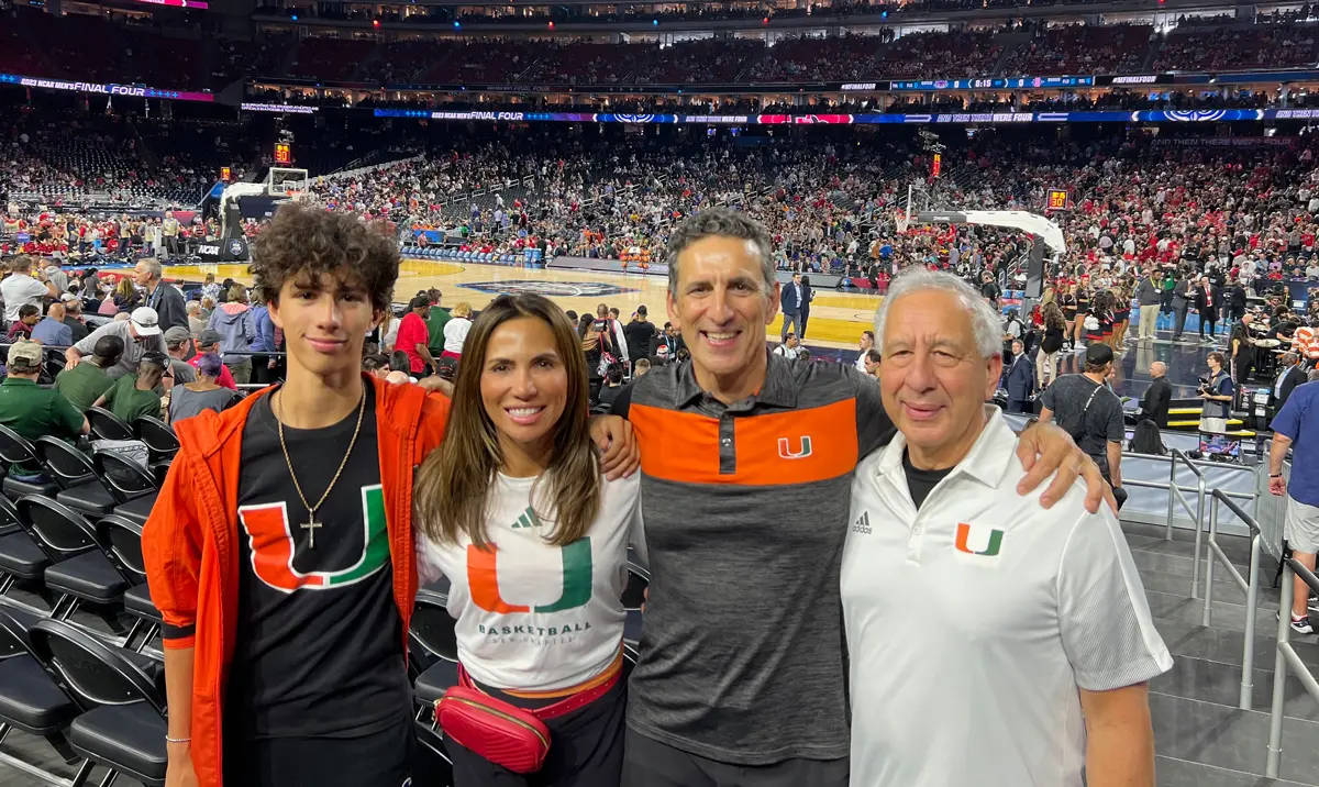 family posing in basketball arena