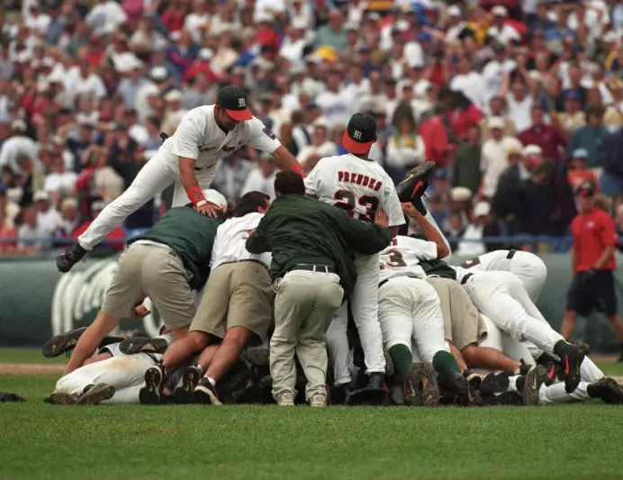 Baseball players diving into a pile in celebration