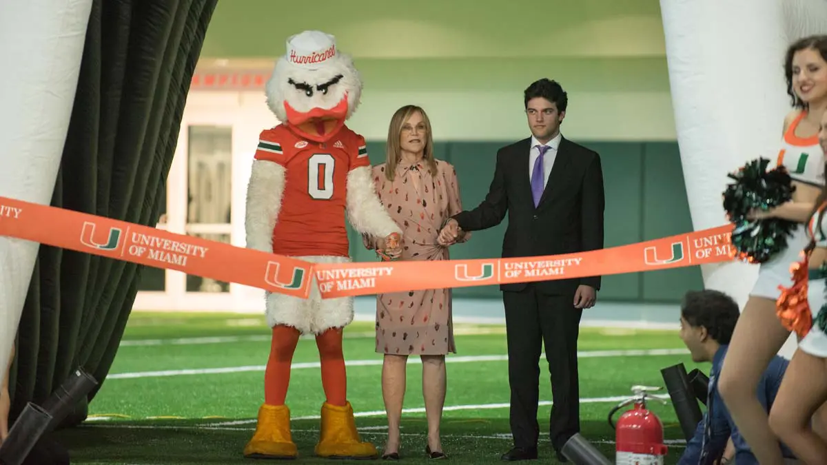 Mascot with a man and woman in front of ribbon